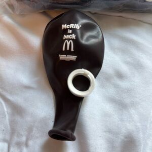 Over a dozen McRib McDonald’s balloons with ribbon spools